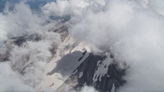 5K aerial stock footage orbit thick clouds to reveal snow on Mount St. Helens' slopes, Washington Aerial Stock Footage | AX52_059