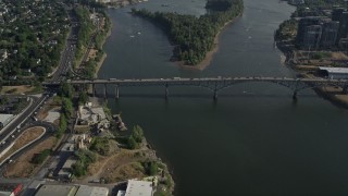 AX53_056E - 5K aerial stock footage of orbiting Ross Island Bridge revealing cityscape, Downtown Portland, Oregon