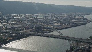 AX53_078E - 5K aerial stock footage of orbiting American Flag atop a bridge revealing skyscrapers and high-rises, Downtown Portland, Oregon