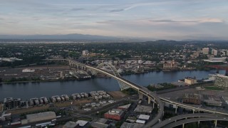 AX54_021E - 5K aerial stock footage of flying by the Fremont Bridge, spanning Willamette River, Downtown Portland, Oregon, sunset