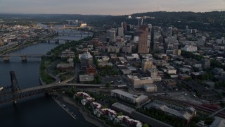 AX54_030 - 5K aerial stock footage of flying by city bridges across the Willamette River, Downtown Portland, Oregon, sunset