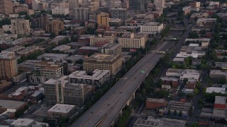 5K aerial stock footage track cars on Interstate 405, tilt to reveal skyscrapers in Downtown Portland, Oregon, sunset Aerial Stock Footage | AX54_085