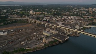 AX54_101E - 5K aerial stock footage pan across the Fremont Bridge, revealing Downtown Portland, Oregon, twilight