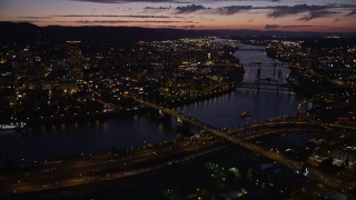 5K aerial stock footage of US Bancorp Tower and bridges along the Willamette River, Downtown Portland, Oregon, twilight Aerial Stock Footage | AX55_018E