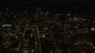 5K aerial stock footage of flying by US Bancorp Tower, and toward Wells Fargo Center, Downtown Portland, Oregon, night Aerial Stock Footage | AX55_053E