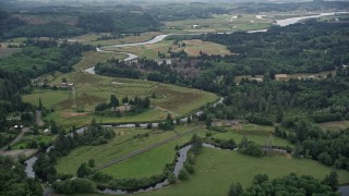 AX56_063E - 5K aerial stock footage of ranch fields and ranch houses around the Youngs River in Astoria, Oregon