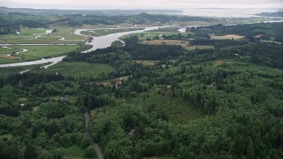 AX56_065 - 5K aerial stock footage approach rural homes by the Youngs River, with ranch fields on the other side, Astoria, Oregon