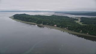 AX56_148E - 5K aerial stock footage fly over green shore and evergreen forest on Long Island, Washington