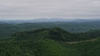 AX57_002 - 5K aerial stock footage approach hills covered by evergreen forest in Satsop, Washington