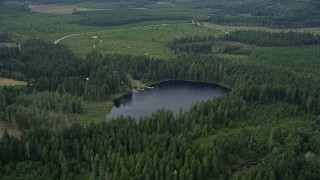 5K aerial stock footage of forest surrounding Panhandle Lake and a campground with docks in Shelton, Washington Aerial Stock Footage | AX57_031