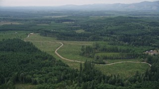 AX57_032 - 5K aerial stock footage of road through a logging clear cut area in Shelton, Washington