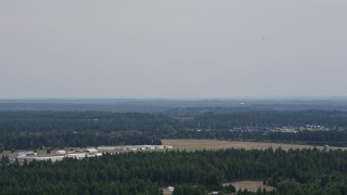 AX57_036E - 5K aerial stock footage of Sanderson Field airport hangars in Shelton, Washington