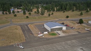 AX58_001 - 5K aerial stock footage of a small hangar and fuel truck at Sanderson Field airport, Shelton, Washington