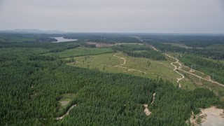 AX58_010 - 5K aerial stock footage approach a logging area and dirt roads from evergreen forest in Shelton, Washington