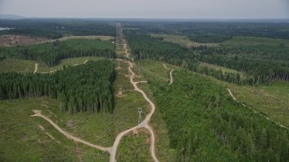 AX58_011 - 5K aerial stock footage fly over dirt roads and a row of power lines in Grapeview, Washington