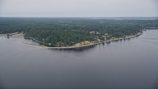 5K aerial stock footage of waterfront homes, beach, and evergreens on the shore of Case Inlet, Vaughn, Washington Aerial Stock Footage | AX58_024E