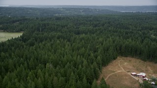 AX58_050E - 5K aerial stock footage of rural homes and evergreen forest by Nelson Road, Olalla, Washington