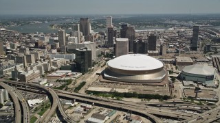 AX59_040E - 5K aerial stock footage fly over freeway interchange to approach Superdome, Downtown New Orleans skyscrapers in Louisiana