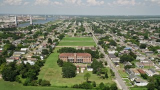 5K aerial stock footage fly over abandoned school to approach homes in the Lower Ninth Ward, New Orleans, Louisiana Aerial Stock Footage | AX59_056