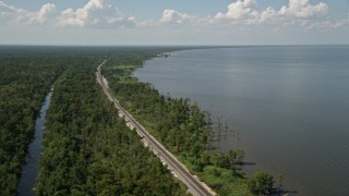 AX60_009 - 5K aerial stock footage of railroad tracks through swampland on the lakeshore in La Place, Louisiana