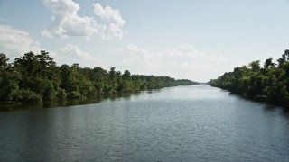 AX60_075 - 5K aerial stock footage fly low over a river between trees and swamps in St. John the Baptist Parish, Louisiana