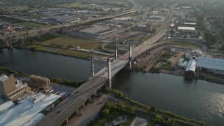 AX61_002E - 5K aerial stock footage fly over warehouse buildings to approach Danziger Bridge at sunset, New Orleans, Louisiana