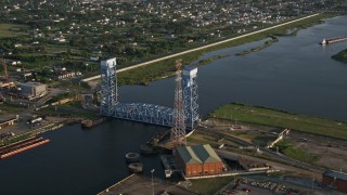 AX61_005 - 5K aerial stock footage the Florida Avenue Bridge, spanning Industrial Canal at sunset, New Orleans, Louisiana