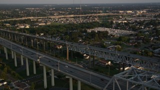 5K aerial stock footage fly over the convention center to track cars on Crescent City Connection Bridge at sunset, New Orleans, Louisiana Aerial Stock Footage | AX61_020