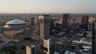 5K aerial stock footage flyby downtown and Plaza Tower to approach Superdome and New Orleans Arena at sunset, New Orleans, Louisiana Aerial Stock Footage | AX61_026E