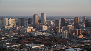 AX61_037 - 5K aerial stock footage of Downtown New Orleans skyscrapers and Iberville Projects at sunset, Louisiana