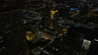 AX62_010E - 5K aerial stock footage fly over Marriott and Sheraton hotels and skyscrapers to approach Superdome at night, Downtown New Orleans, Louisiana