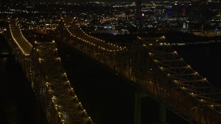 5K aerial stock footage orbit light traffic on the Crescent City Connection Bridge at night, New Orleans, Louisiana Aerial Stock Footage | AX62_016