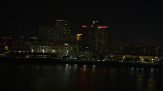 5K aerial stock footage of low altitude view of riverfront skyscrapers in Downtown New Orleans at night, Louisiana Aerial Stock Footage | AX62_031