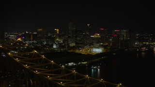 5K aerial stock footage reverse view of Downtown New Orleans at night, reveal Crescent City Connection, Louisiana Aerial Stock Footage | AX62_032