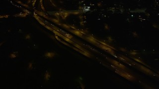 5K aerial stock footage of reverse and bird's eye view of freeway interchange at night, New Orleans, Louisiana Aerial Stock Footage | AX62_049