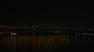 AX63_011 - 5K aerial stock footage track and ambulance crossing Crescent City Connection Bridge at night, New Orleans, Louisiana