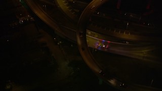 AX63_012E - 5K aerial stock footage ambulance near the Crescent City Connection Bridge at night, New Orleans, Louisiana