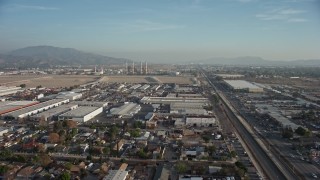 5K aerial stock footage fly over homes and warehouses to approach power plant smoke stacks, Sun Valley and Pacoima, California Aerial Stock Footage | AX64_0044