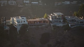 AX64_0121E - 5K aerial stock footage approach and flyby  hilltop mansions in Hollywood Hills, California, sunset