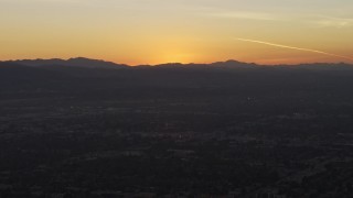 5K aerial stock footage of the sun setting behind the Hollywood Hills in California, sunset Aerial Stock Footage | AX64_0148E