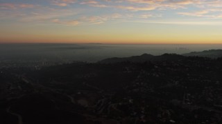 AX64_0162E - 5K aerial stock footage of passing hillside mansions in Hollywood Hills, California, twilight