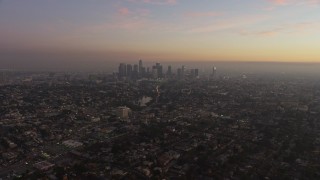 AX64_0179E - 5K aerial stock footage of Downtown Los Angeles surrounded by city sprawl, California, twilight