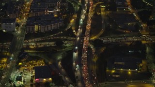 AX64_0253 - 5K aerial stock footage of reverse view of heavy traffic on 101 and 110 freeways in Downtown Los Angeles, California, Night