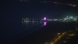 AX64_0298 - 5K aerial stock footage of approaching iconic Santa Monica Pier and the Pacific Wheel at night, Los Angeles, California