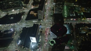 AX64_0319E - 5K aerial stock footage of tilt from bird's eye view of Wilshire Boulevard to condominium complexes in Westwood, Los Angeles, California, night