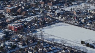 AX66_0033E - 4.8K aerial stock footage of a residential neighborhood and sports field in snow, Great Neck, New York