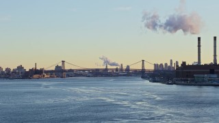 AX66_0226E - 4.8K aerial stock footage approach the Williamsburg Bridge on East River, New York City sunset