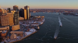 AX66_0257 - 4.8K aerial stock footage of ferries on East River by Battery Park, Lower Manhattan in snow, New York City, sunset