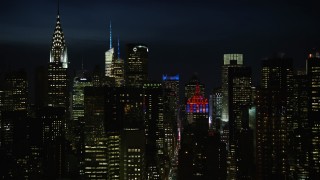 4.8K aerial stock footage of Chrysler Building, city canyons and the Empire State Building in Midtown Manhattan, New York City, night Aerial Stock Footage | AX66_0443E