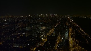 4.8K aerial stock footage view orbit Lerner Hall and snowy campus at Columbia University at night, reveal Midtown, New York City, New York Aerial Stock Footage | AX67_0006